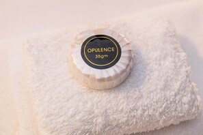 A white, fluffy, textured surface with a circular object that has 'OPULENCE 35gm' written on it.