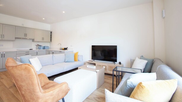 A modern living room with a sofa, armchairs, a coffee table, and a flat-screen TV. - Modern 3BD Split-Level Home with Balcony,Dublin 16 (Dublin)