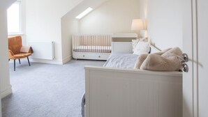 A child's bedroom with a crib, a bed, a chair, and a radiator. - Modern 3BD Split-Level Home with Balcony,Dublin 16 (Dublin)