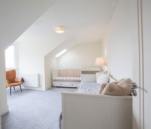 A child's bedroom with a crib, a bed, a chair, and a radiator. - Modern 3BD Split-Level Home with Balcony,Dublin 16 (Dublin)