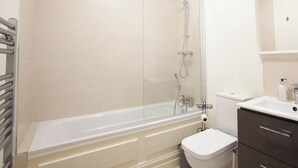 A modern bathroom with a bathtub, toilet, and a shower. - Modern 3BD Split-Level Home with Balcony,Dublin 16 (Dublin)