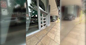 Ein Gebäude mit Glasfassade, einem Rauchverbotsschild und einem parkenden Auto.
