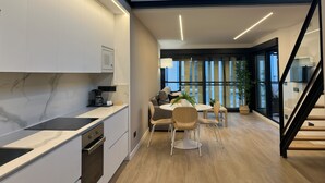 Una cocina moderna con microondas integrado, cafetera y zona de comedor con mesa redonda y sillas.