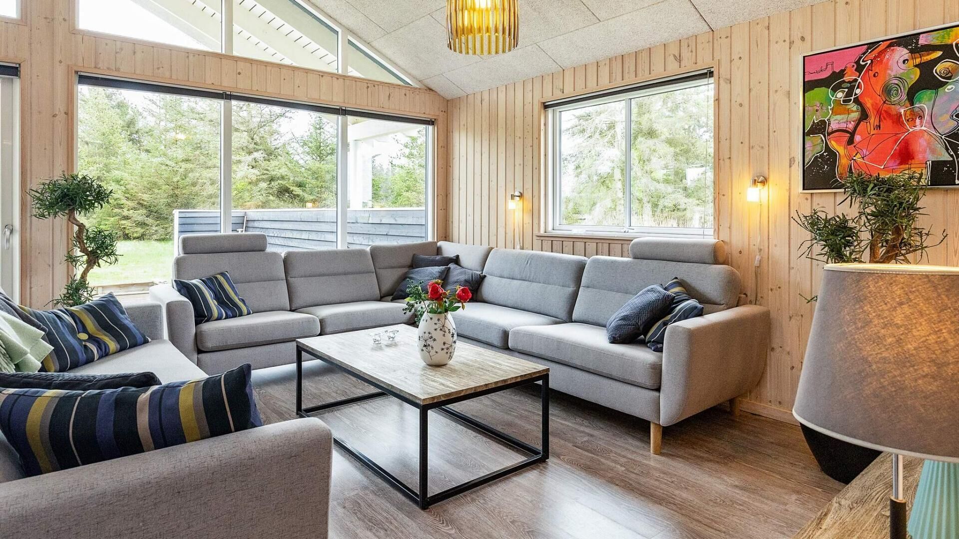 Una sala de estar moderna con un sofá modular, una mesa de centro y un cuadro en la pared.