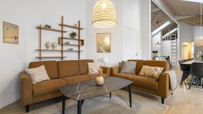 A modern living room with a sofa, coffee table, and decorative shelves.