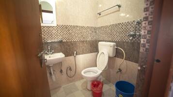A bathroom with a toilet, sink, and a shower area.
