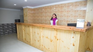 A reception desk with a wooden finish and a sign on top. - Paundur Community Homestay (Pokhara)