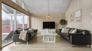 Un salon moderne avec deux canapés, une table basse et un téléviseur.
