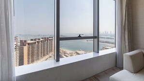Ein Zimmer mit großem Fenster und Blick auf eine Stadtlandschaft sowie ein Gewässer.