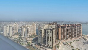 Un complejo residencial de edificios altos con varios edificios de apartamentos, un puerto deportivo y una vista despejada del horizonte de la ciudad.