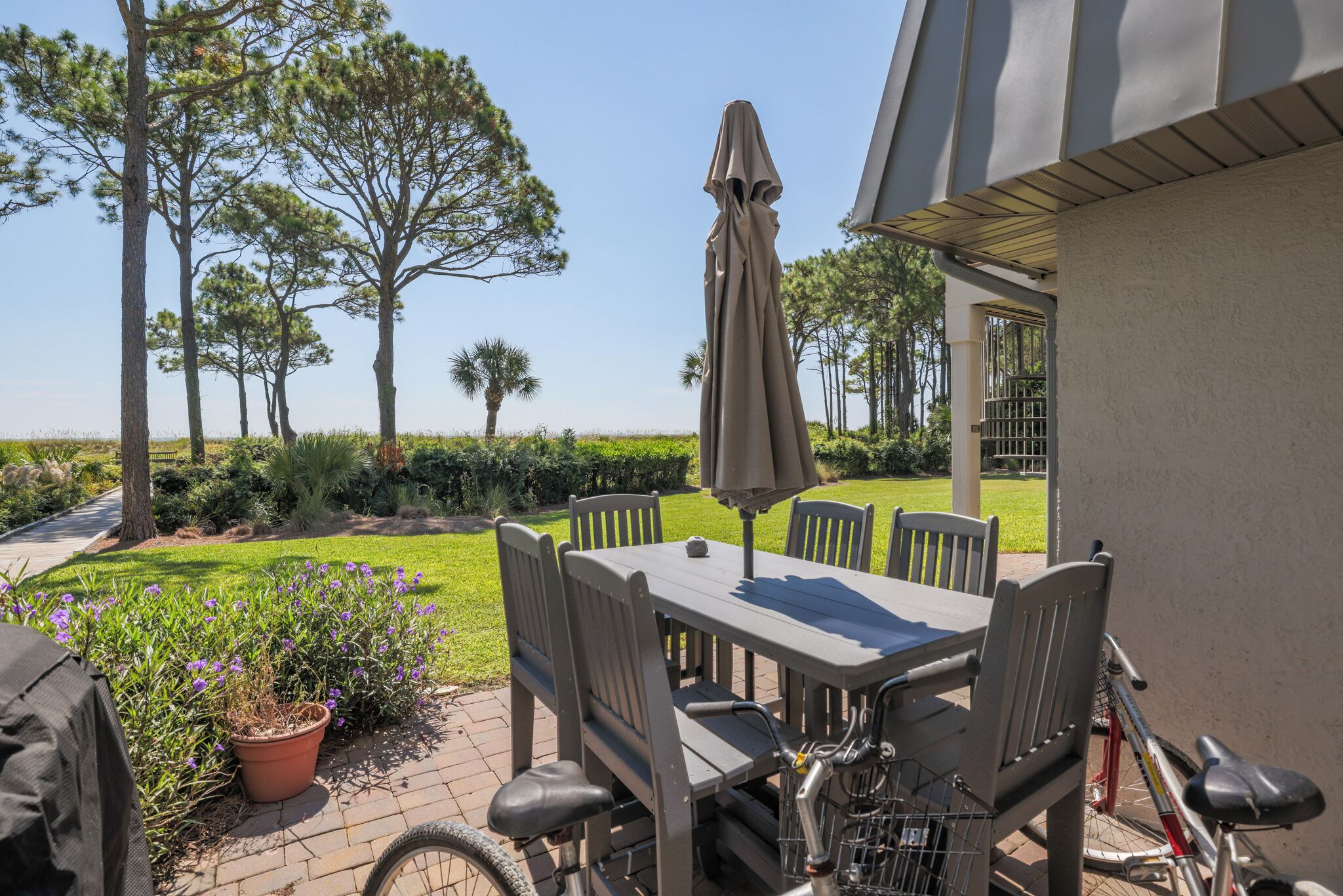 A patio with a table and chairs, a bicycle, and a potted plant.