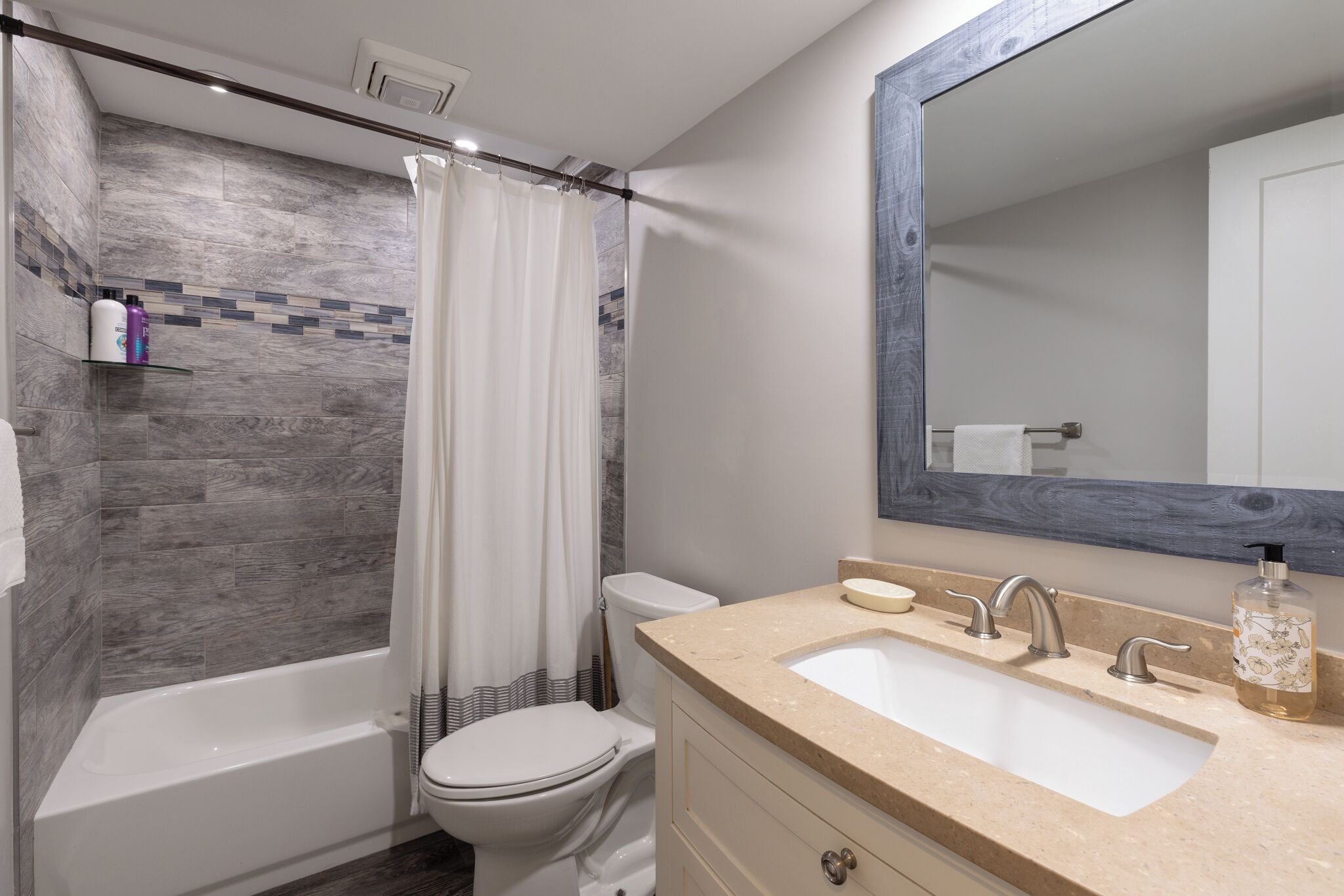 A modern bathroom with a bathtub, toilet, and sink.
