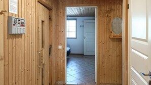 A wooden hallway leading to a room with a bed, a window, and a door. - VillaVilla 78 - Öland, Sverige (Köpingsvik)