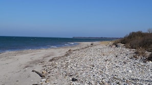 A pebbly beach with a clear view of the ocean and a distant shoreline. - VillaVilla 424 - Skåstrup Strand, Fyn og øer (Bogense)