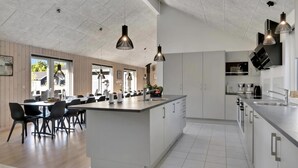 A modern kitchen with a central island, white cabinetry, and pendant lighting. - VillaVilla 436 - Asserbo/Liseleje, Nordsjælland (Frederiksværk)