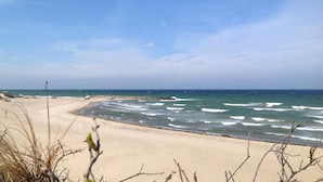 A beach with waves, a pier, and sparse vegetation. - VillaVilla 436 - Asserbo/Liseleje, Nordsjælland (Frederiksværk)