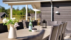 A table with a bottle of Pellegrino water, a bowl of olives, and a vase of flowers. - VillaVilla 436 - Asserbo/Liseleje, Nordsjælland (Frederiksværk)