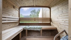 A wooden cabin with a bench, a small table, and a view through a window.