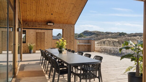 A wooden deck with a dining table and chairs, overlooking a natural landscape. - VillaVilla 660 - Henne Strand, Vestjylland (Henne)