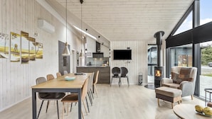 A modern interior with a dining area, kitchen, and a fireplace.