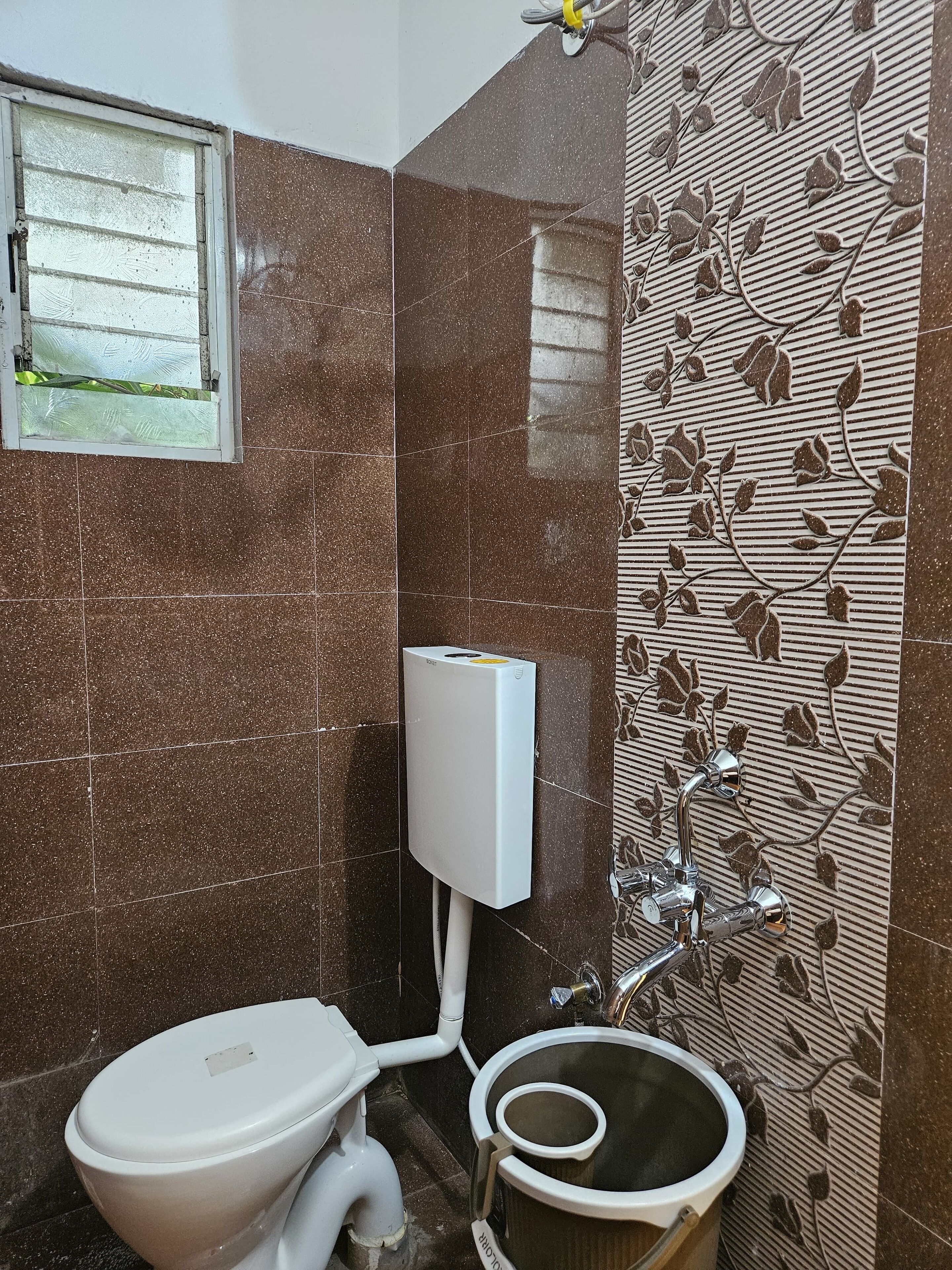 A bathroom with a toilet, bidet, and a water heater mounted on the wall.