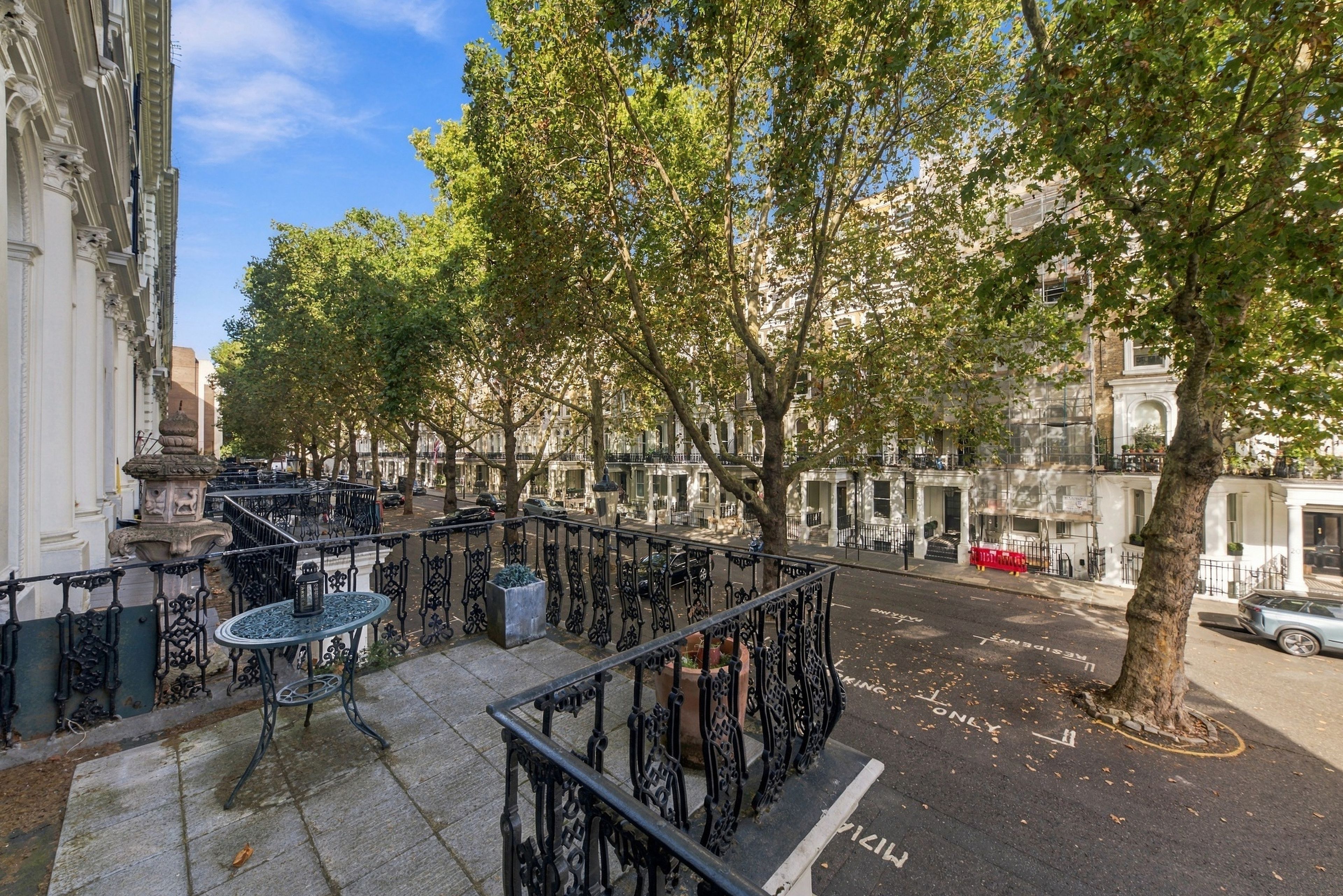 A street with trees, a sidewalk, and buildings.