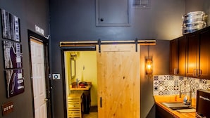 Una cucina compatta con un piano di lavoro in legno, un lavello e un frigorifero.