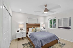 A bedroom with a bed, nightstands, a ceiling fan, and a window. - World Cup Group Stay · Sleeps 12 · POOL (Fort Lauderdale)
