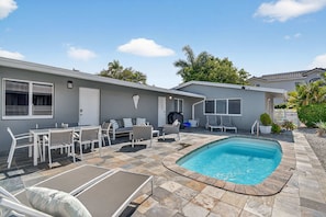 A residential property with a swimming pool, outdoor seating, and a covered patio area. - World Cup Group Stay · Sleeps 12 · POOL (Fort Lauderdale)