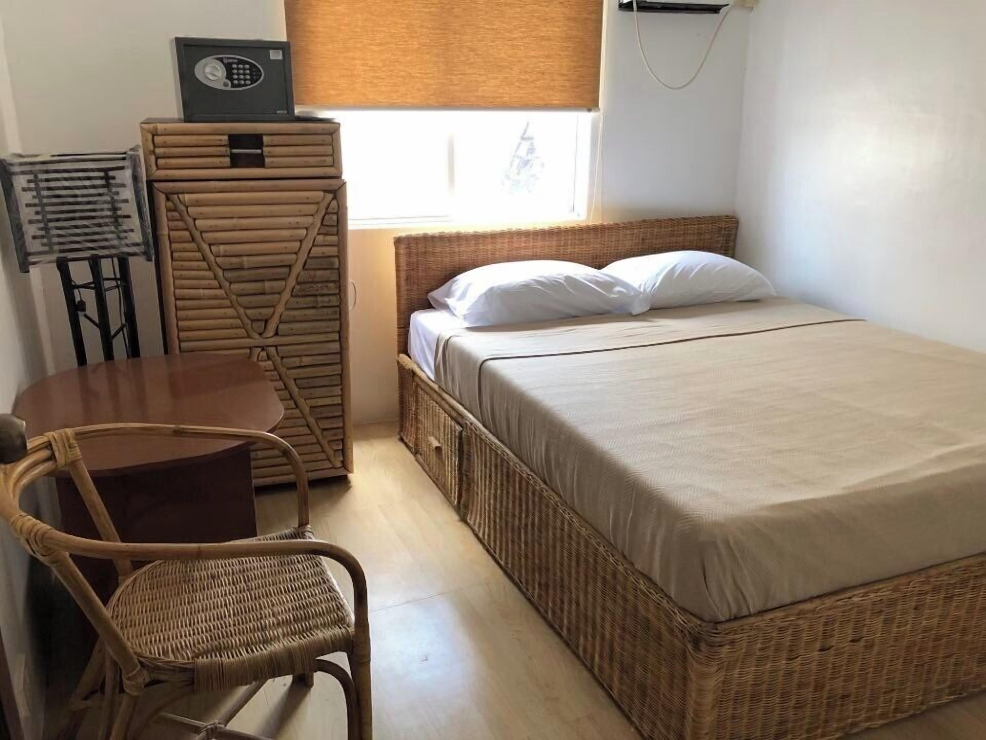 Une petite pièce comprenant un lit, une petite table et une chaise.
