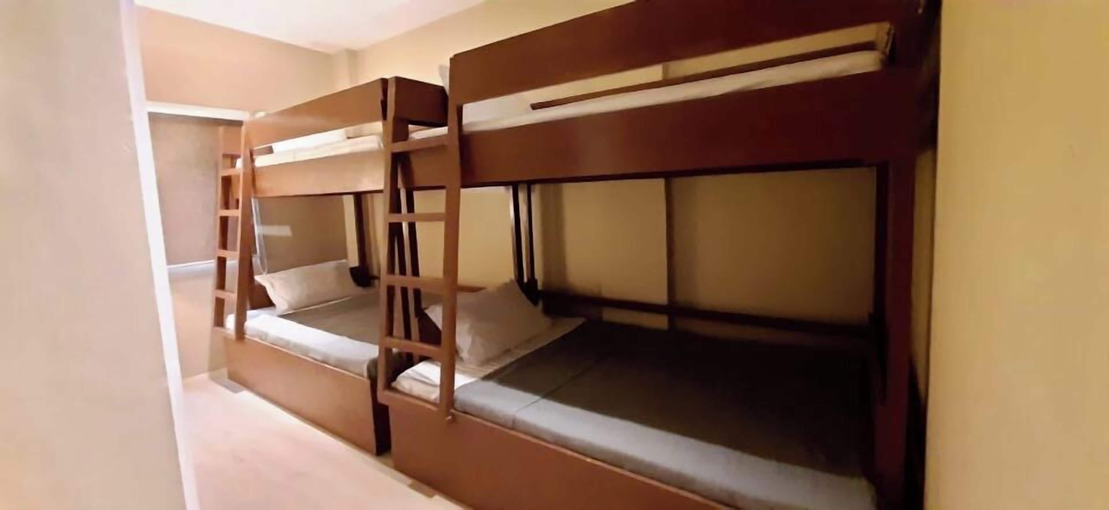 Una habitación con literas, una escalera y una ventana.