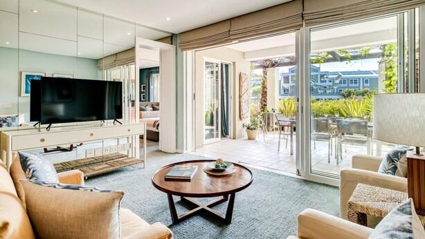 Een moderne woonkamer met een flatscreen televisie, een ronde salontafel en een bank.