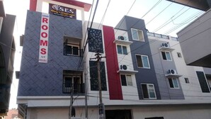 A multi-story building with a sign indicating rooms are available.