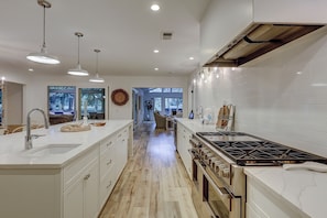 A modern kitchen with a central island, stainless steel appliances, and pendant lighting. - Escape to Coastal Elegance at 259 Greenwood Drive (Hilton Head Island)