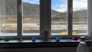 A window with a view of a river and hills.