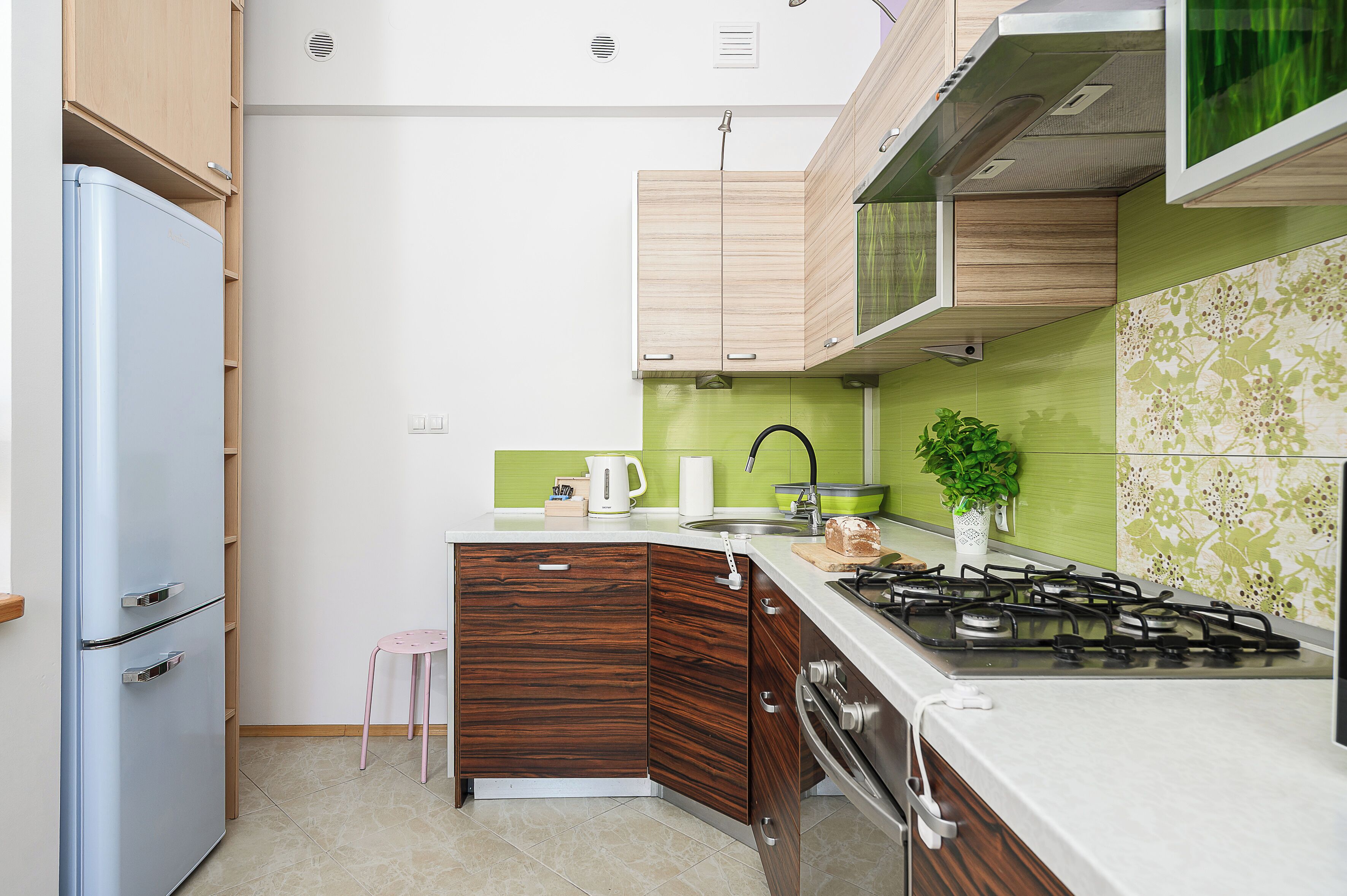 A compact kitchen with a built-in gas stove, a sink, and a small refrigerator.
