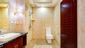 Un baño con lavabo de mármol, inodoro y ducha.