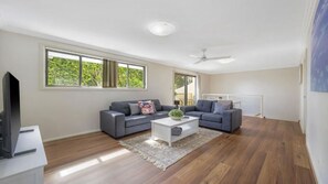 Amplia sala de estar con dos sofás, una mesa de centro y un televisor.