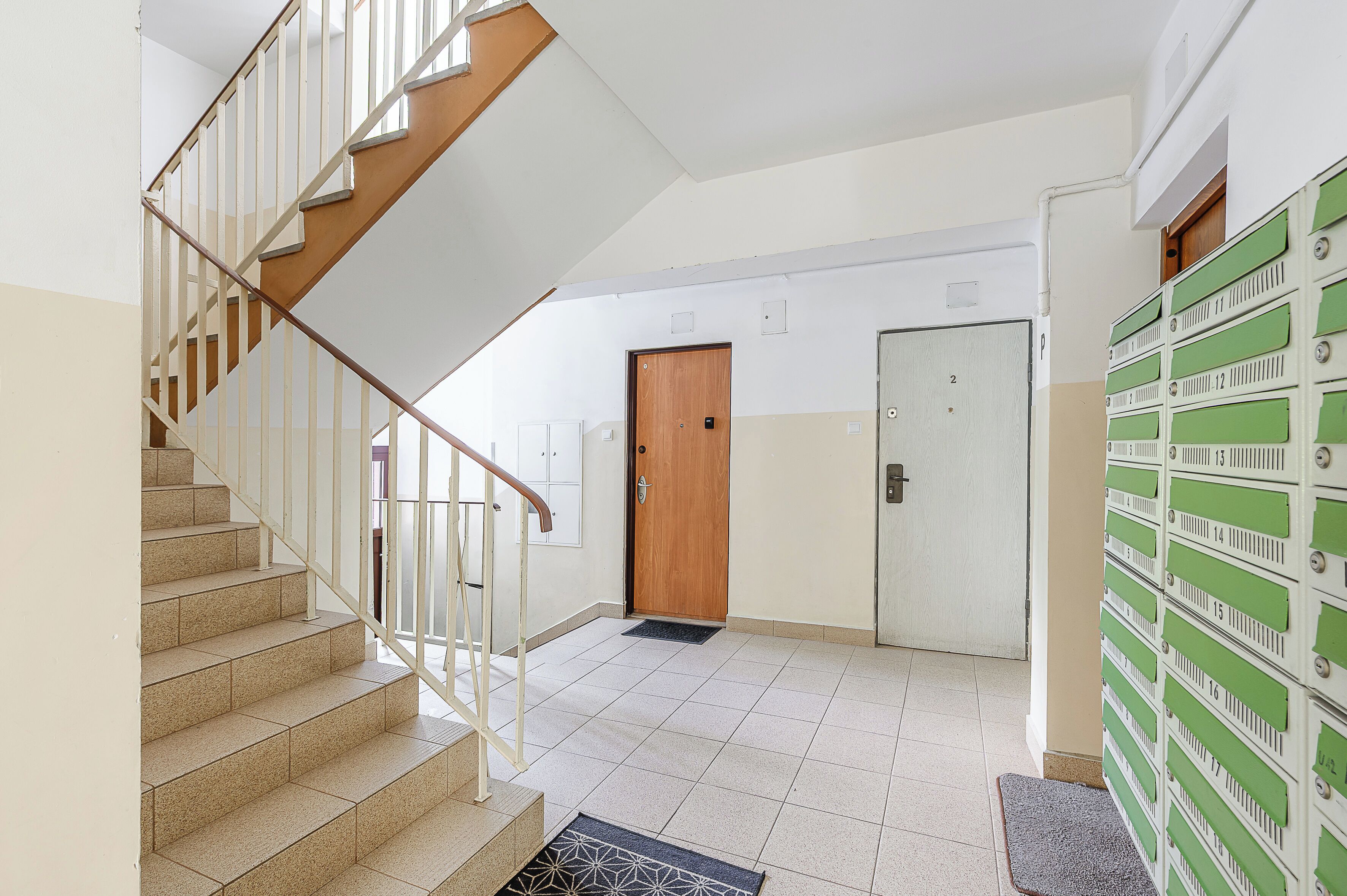 Eine Treppe mit Holzdielen und weißen Geländern, die zu einer Zwischenebene führt.
