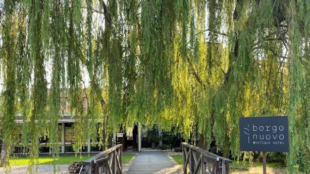 A wooden bridge leading to a building with a sign reading "borgo nuovo boutique hotel". - Boutique Hotel Borgo Nuovo (Milan)