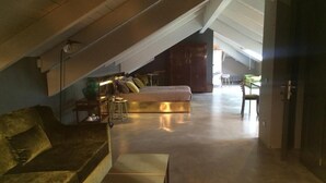 A spacious loft bedroom with a large bed, a sofa, and a desk. - Boutique Hotel Borgo Nuovo (Milan)