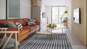 A modern living room with a brown leather sofa, a patterned rug, and a wooden coffee table.