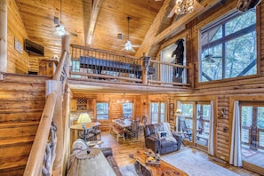 A log cabin with a dining area, a living room with a fireplace, and a balcony with a bear statue. - Rustic Retreat - view-pets-games-hot tub-fire pit (Mineral Bluff)