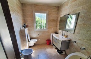 Ein Badezimmer mit Toilette, Bidet, Waschbecken und Badewanne.