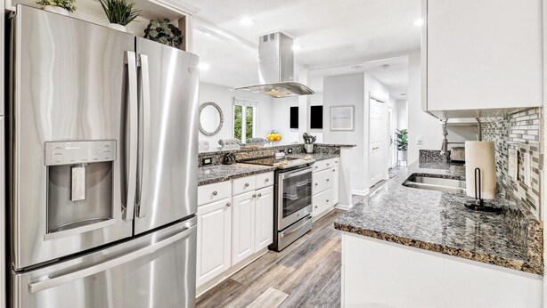 A modern kitchen with stainless steel appliances, granite countertops, and white cabinetry. - 3 Bedroom retreat with private pool (Hilton Head Island)