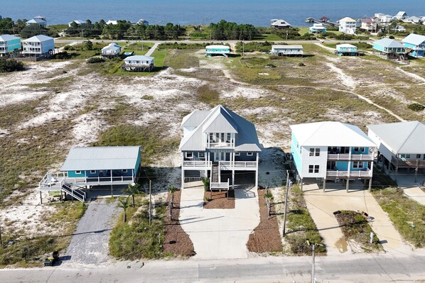 A coastal property with multiple beachfront houses, each featuring a balcony and a garage.