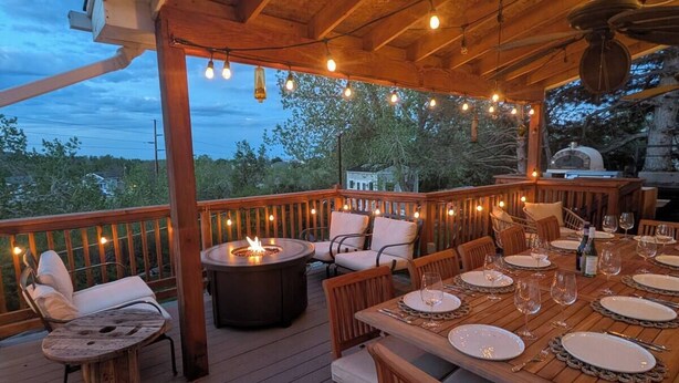Eine Terrasse im Freien mit einem Esstisch, gedeckt für sechs Personen, umgeben von Stühlen.