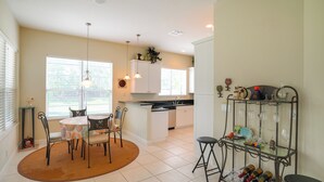 A kitchen with a dining area, a wine rack, and a small table with chairs. - Swim & Golf: Family Home 2 Mi to Clover Park! (Port Saint Lucie)