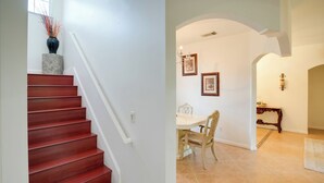 A staircase with a red finish and a vase with decorative branches on the landing. - 5 Mi to Boating! Port St Lucie Home w/ Backyard (Port Saint Lucie)
