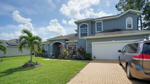 A two-story house with a garage, a paved driveway, and a well-maintained lawn. - 5 Mi to Boating! Port St Lucie Home w/ Backyard (Port Saint Lucie)